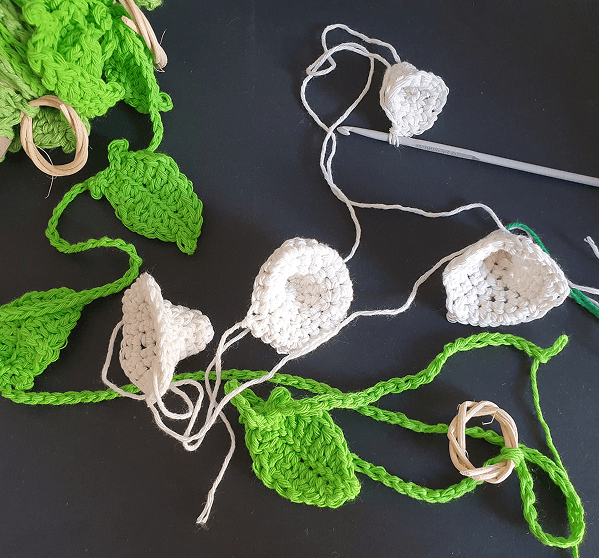 Crocheted white flowers with bright green leaves